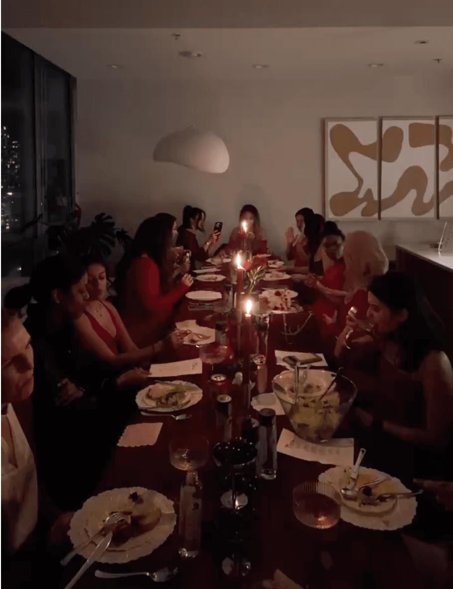Candlelit long-table dinner with members in red